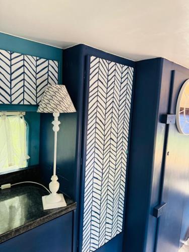 a blue room with a lamp and a blue wall at Penhallow House in Newlyn East
