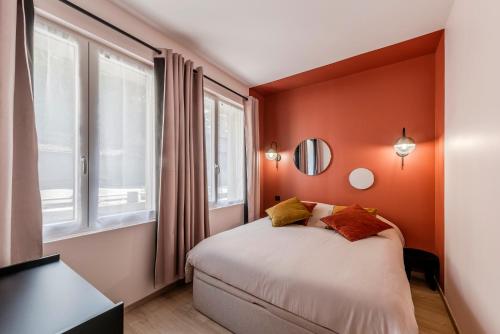 - une chambre avec un lit aux murs orange et des fenêtres dans l'établissement Le Cotin des Cordiers 2, F2 hypercentre, avec parking, au Tréport