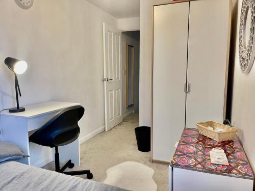 a bedroom with a bed and a desk and a mirror at Private room in BS14 in Bristol