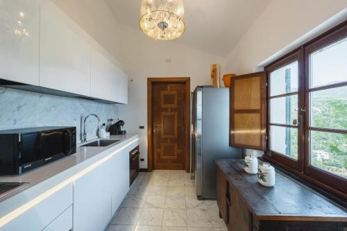 a kitchen with a sink and a refrigerator at Villa with Pool - Unique Sea View - Free Parking in Zoagli