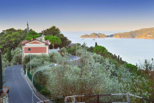 a house on a hill next to a body of water at Villa with Pool - Unique Sea View - Free Parking in Zoagli