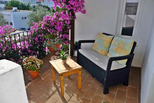 a patio with a couch and a table and flowers at Matriz Home in Portel