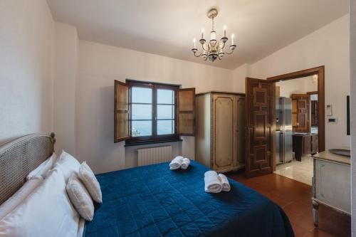 a bedroom with a blue bed with towels on it at Villa with Pool - Unique Sea View - Free Parking in Zoagli