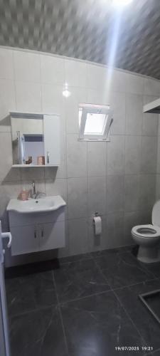 a white bathroom with a sink and a toilet at Likya Vadi Evleri Nature and tranquility in Antalya