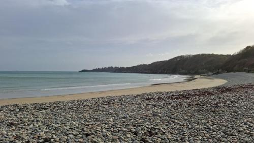 a beach with a rocky shoreline and the ocean at Heart of Tréguier Ideal for 2 people in Tréguier