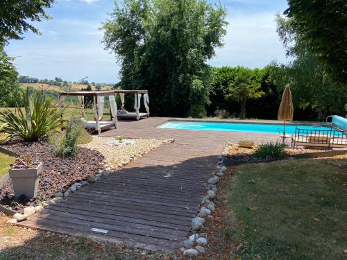 une cour avec une piscine et une aire de jeux dans l'établissement La Longere De Cabanes, à Cabanès