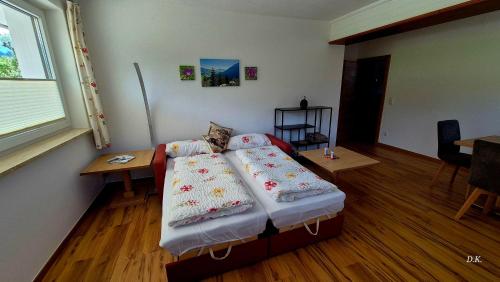 a bedroom with a bed and a table and a window at Appartement Kaufmann in Westendorf