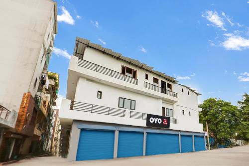 a white building with blue garage doors on a street at Super Hotel O A K Residency in New Delhi