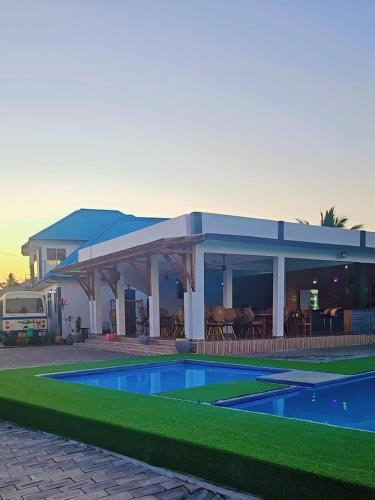 a house with a swimming pool in front of it at Chibuba Airport Accommodation in Dar es Salaam