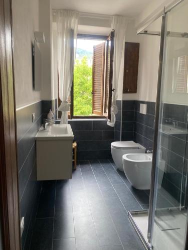 a bathroom with a sink and a toilet and a window at La Corte dei Lillà in Castiglione dei Pepoli