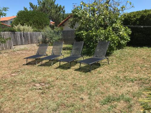 a row of chairs sitting in a yard at Villa Tamaris in Glanon
