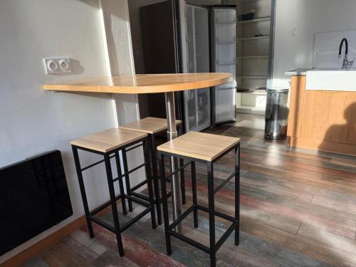a kitchen with a table and two stools at Villa Tamaris in Glanon
