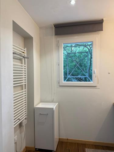 a white room with a window and a refrigerator at Villa Tamaris in Glanon