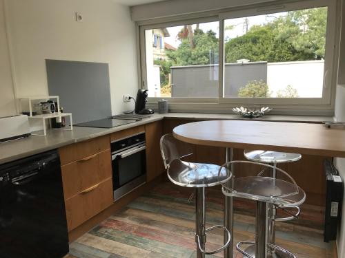 a kitchen with a table and two bar stools at Villa Tamaris in Glanon