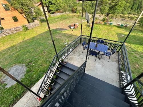 a balcony of a house with a table and chairs at Tariba Guesthouse & Camping in Mestia