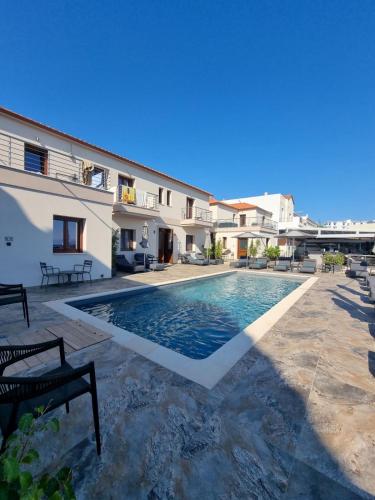 a villa with a swimming pool in front of a building at La vie luxury suites in Megalochori