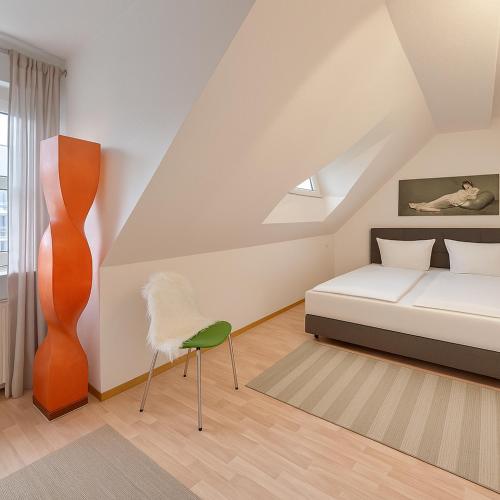 a bedroom with a bed and a chair in it at TOP für Monteure -Maisonette Duplex Wohnung in Bad Kreuznach