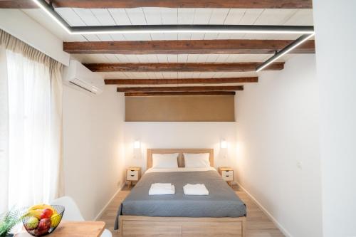 a bedroom with a bed and a table and a window at Rethymno Dome Garden in Rethymno