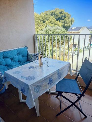 - une table avec 2 verres à vin et 2 chaises sur le balcon dans l'établissement Bandol - 