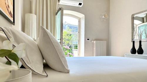 a bedroom with a large white bed with white pillows at Borgo dei Sogni - Deluxe Apartment - Lago di Garda in San Felice del Benaco