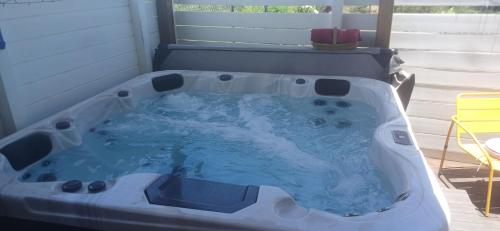 a jacuzzi tub in a room with a window at Gîtes Capra Pomme Surette piscine et spa in Bouillante