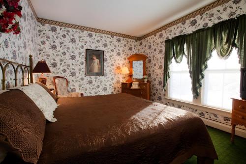 a bedroom with a large bed with floral wallpaper at Stroudsmoor Country Inn in Stroudsburg