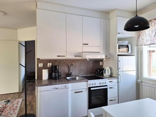 a kitchen with white cabinets and a sink at Jääskän Loma, Kojolapark asunto 2 in Voltti