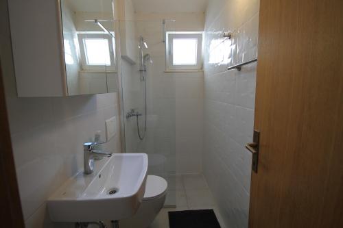 a white bathroom with a sink and a shower at Villa Hortus in Neum