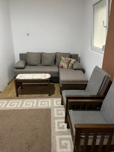 a living room with a couch and a coffee table at Ušuškana kućica "Gočka" in Mataruška Banja