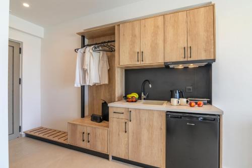 a kitchen with wooden cabinets and a sink and a dishwasher at Elafonisi Pearl in Elafonisi