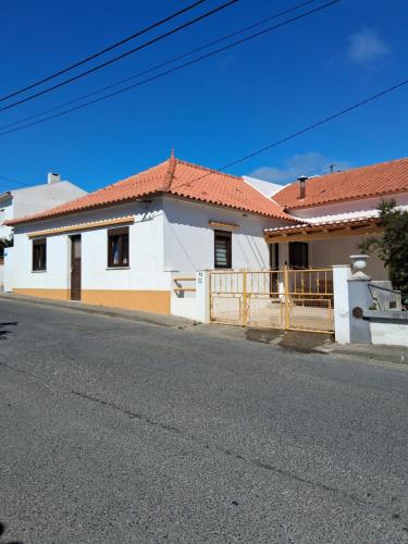 a white house with red roofs on a street at Casa d'Avó in Araújo