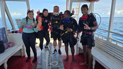 a group of people in scuba gear on a boat at Liberty Guesthouse Maldives in Mahibadhoo