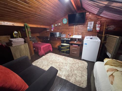 Una sala de estar con un sofá y un televisor en una habitación. en Ático com Ar Condicionado Q e F, en Ponta Grossa
