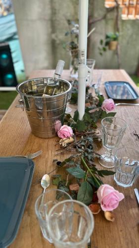 a wooden table with pink roses and candles on it at Avaluna 6 osobe max - shower outside tus spolja in Vrčin