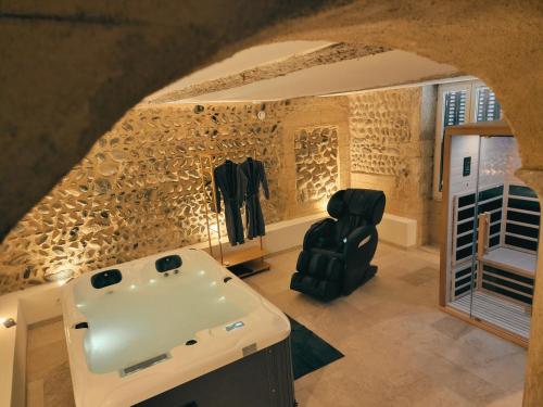 a bathroom with a tub and a chair in a room at Love Room Valence in Valence
