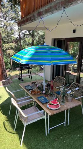 a picnic table with a blue and blue umbrella at Avaluna 6 osobe max - shower outside tus spolja in Vrčin