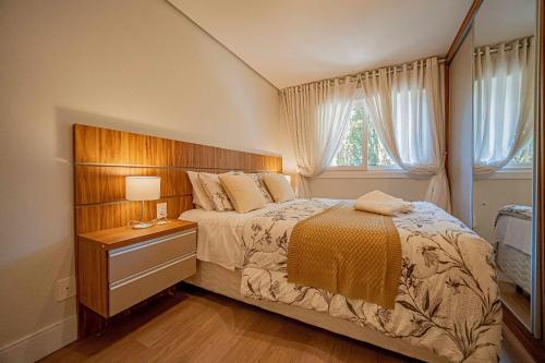 a bedroom with a large bed with a wooden headboard at L'Adresse Réserve 150m R Coberta by Achei Gramado in Gramado