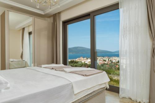 a bedroom with a bed and a large window at Villa Tivat in Tivat