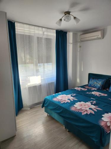 a bedroom with a bed and a window with blue curtains at Gara De Nord 3 Rooms Apartment Superb City View in Bucharest