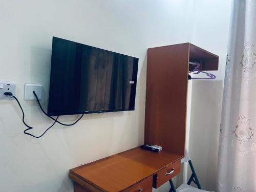 a flat screen tv hanging on a wall at Elly Villa Hotel in Moshi