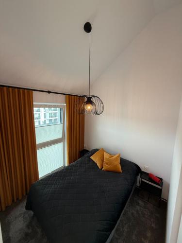 een slaapkamer met een zwart bed en een raam bij Sunny Jantar in Jantar