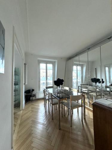 - une salle à manger avec une table, des chaises et des miroirs dans l'établissement Paris Eiffel Tower, à Paris