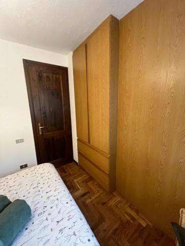 a bedroom with a bed and a wooden door at Petit Nid in Remondey