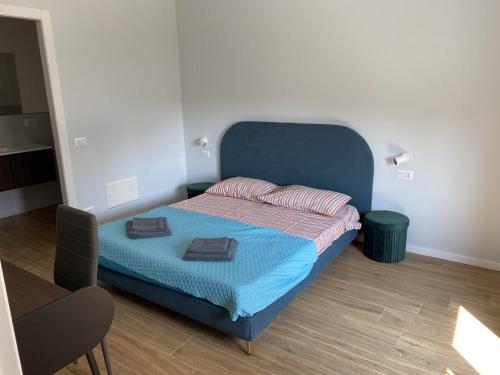 a bedroom with a blue bed with two towels on it at Grande Appartamento familiare - 3 camere 3 bagni - P1 in Cantù