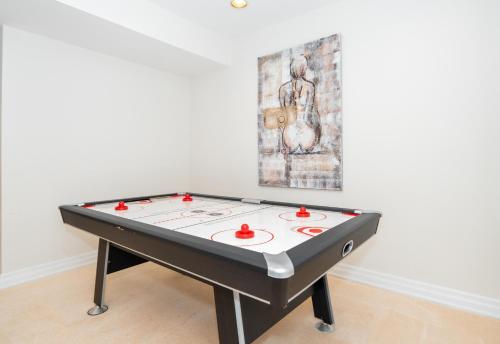 a ping pong table in a room with a painting at Frybrook in Richmond Hill