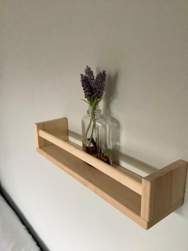 a wooden shelf with a vase with flowers in it at Lorton Villa with a Log Burner in Saint Helens