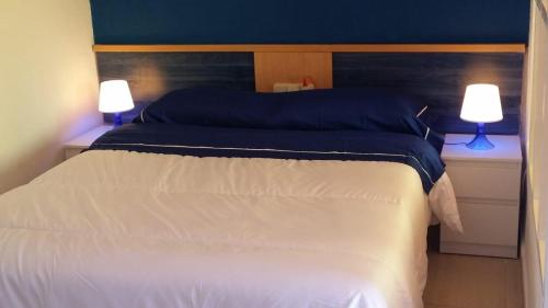 a bedroom with a large bed with two lamps at Aloha 1º linea playa Benalmadena in Benalmádena
