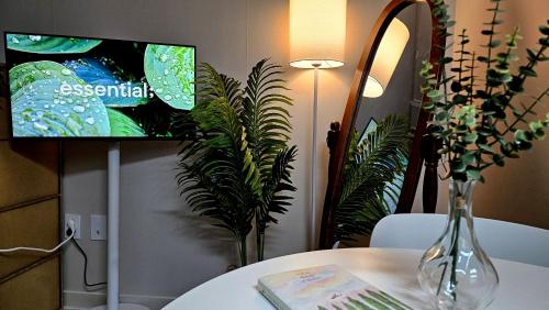 a tv sitting on a table with a vase on a table at Maru Stay in Seoul