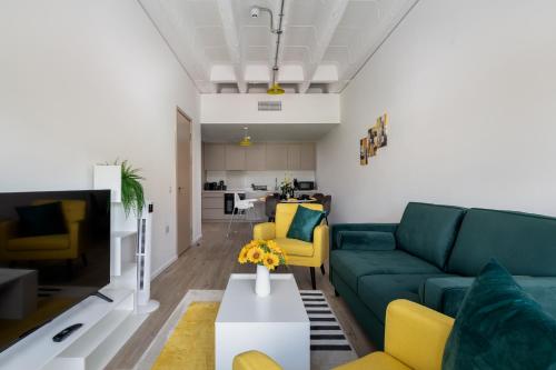 a living room with a green couch and yellow chairs at Quiet and Large with Free Parking Ideal for Families and Business Stays in Milton Keynes