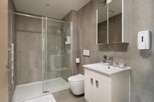 a bathroom with a shower and a toilet and a sink at Quiet and Large with Free Parking Ideal for Families and Business Stays in Milton Keynes